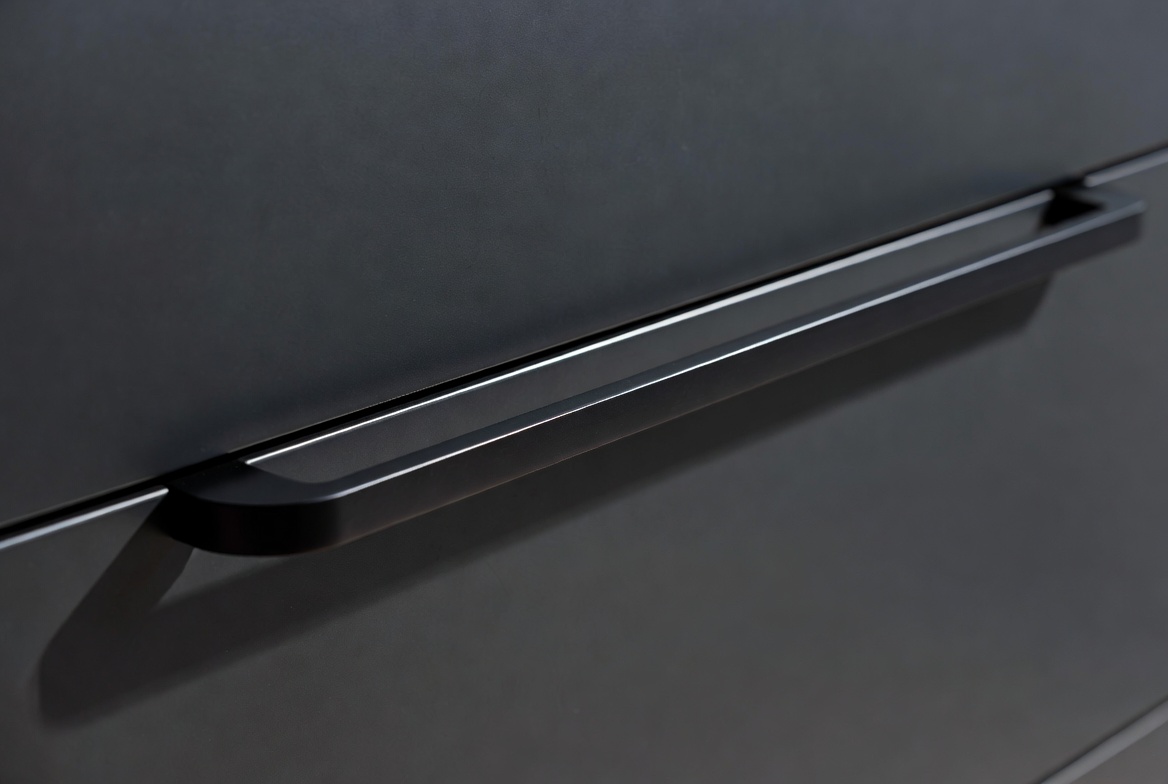 Matte black pull handle on a dark custom cabinet door